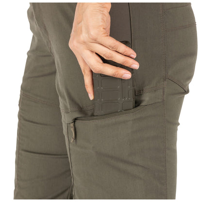 Close-up of a person wearing olive green pants with a pocket detail.