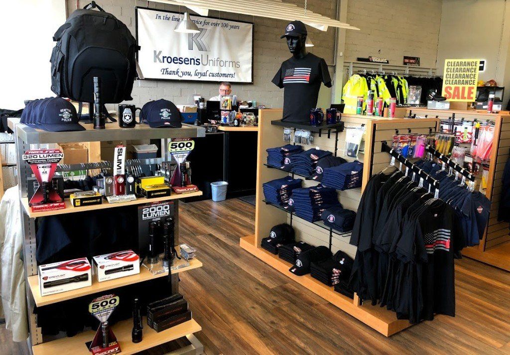 Kroesen's Uniform store interior with merchandise including backpacks, hats, and clothing displayed on shelves.